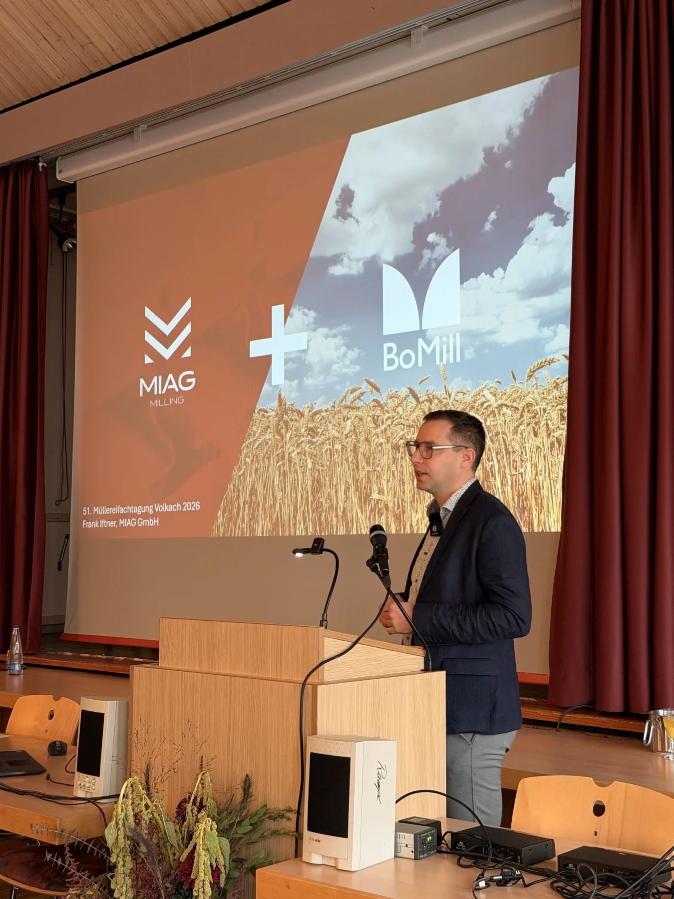 Frank Iftner am Rednerpult vor einer Präsentation von MIAG und BoMill