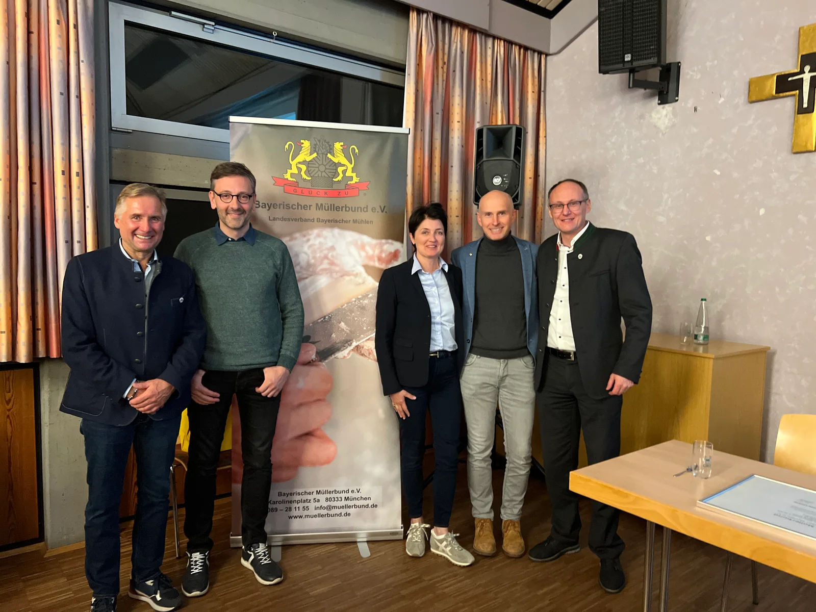Gruppenfoto mit fünf Personen vor dem Banner des Bayerischen Müllerbundes bei der Tagung in Volkach